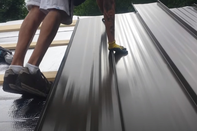 Worker on standing seam roof